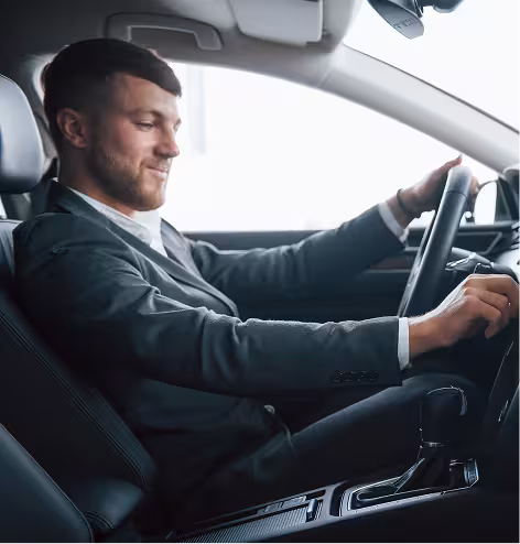A man in a suit driving a car